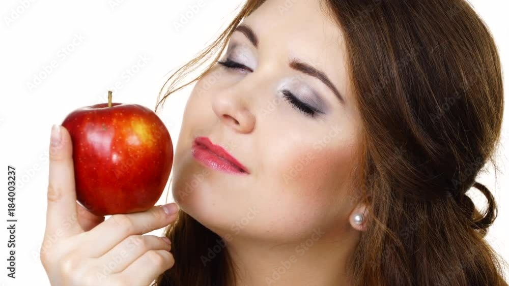 Woman holding red apple in hand close to face, smelling fruit isolated on white. Healthy eating, high fibre diet concept Woman holding red apple in hand close to face, smelling fruit isolated on white. Healthy eating, high fibre diet concept