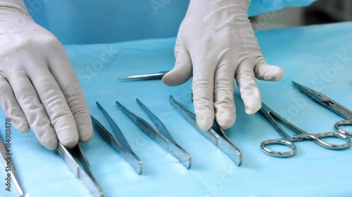 Assistant prepares surgical instruments before surgery photo