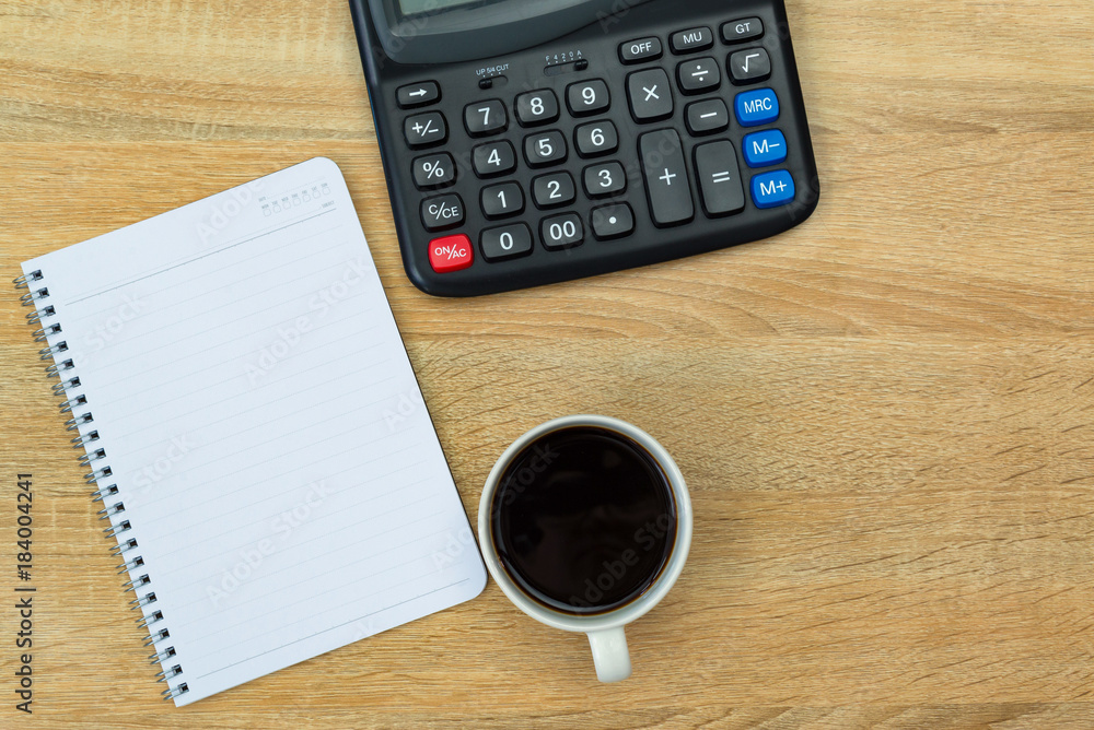 Calculator and cup of coffee with note on working table with copy space top view. Calculator and cup of coffee with note on working table with copy space top view.
