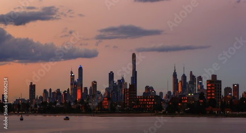 Melbourne city skyline Australia at dusk with the orange glow of the sun reflecting from it’s glass window’s.