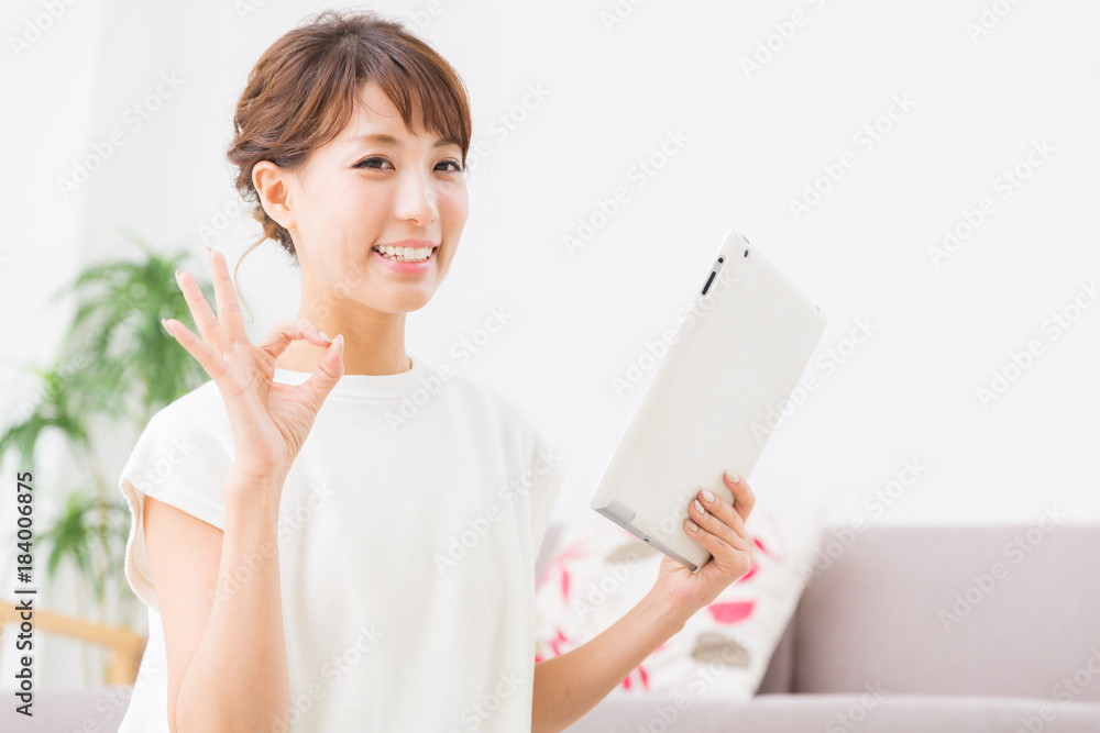 部屋でタブレットを見る女性 部屋でタブレットを見る女性