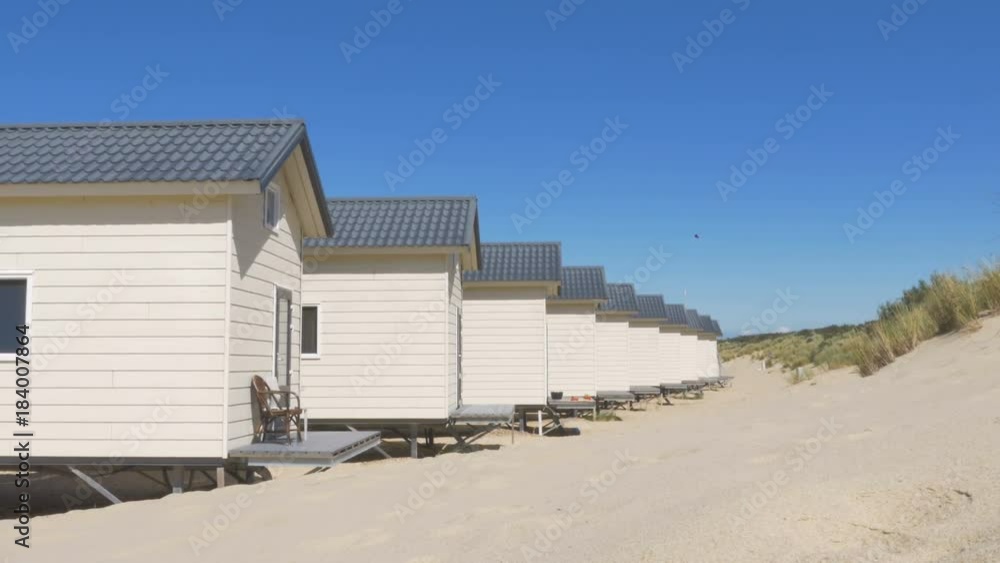 A beach in Zeeland with rows of bungalow summer houses filmed on a bright sunny summer day. A beach in Zeeland with rows of bungalow summer houses filmed on a bright sunny summer day.