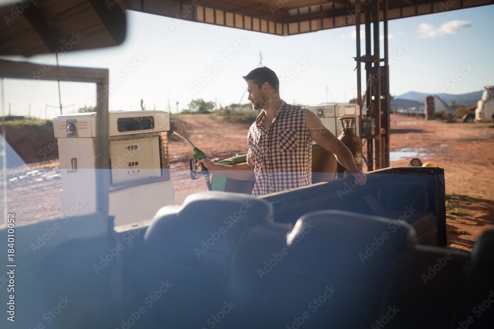 Man filling petrol in car at petrol pump