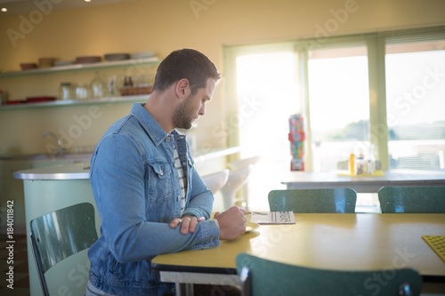 Man reading newspaper while having coffee