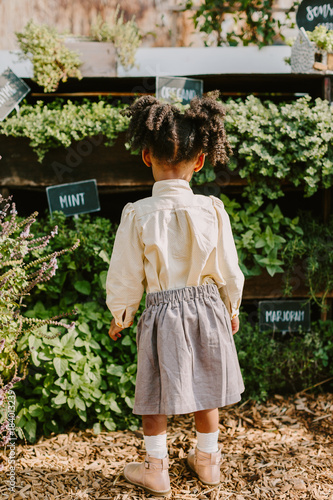 A little girl looking towards garden / plants