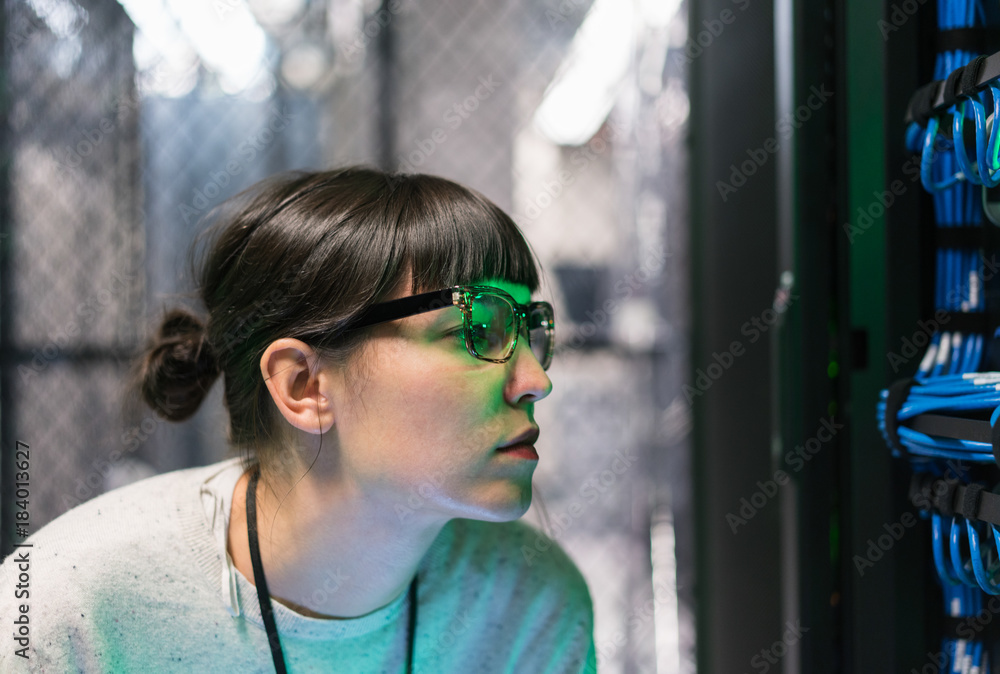 Close up of server room technicians face lit green Close up of server room technicians face lit green