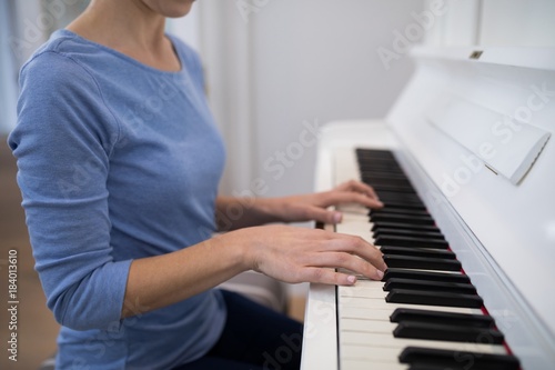 Mid section woman playing piano