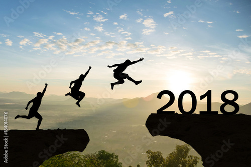 Men jump over silhouette Happy New Year 2018