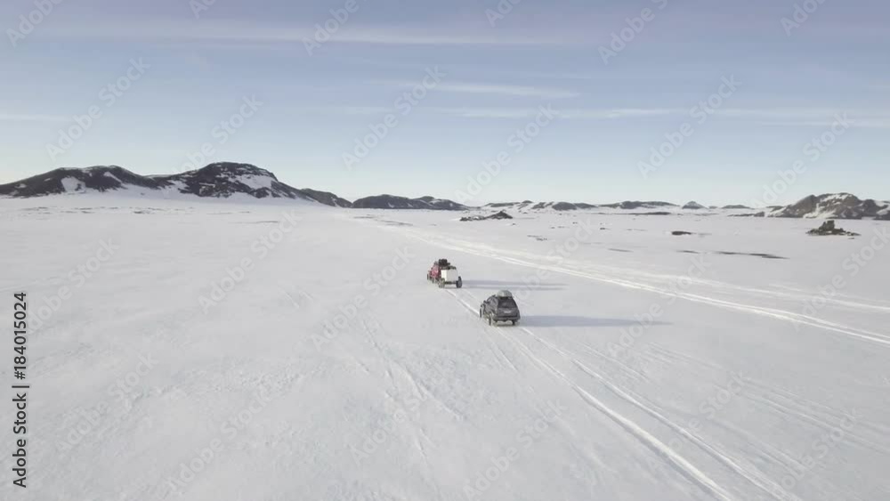 Aerial, cars drive off road on snowy Iceland landscape