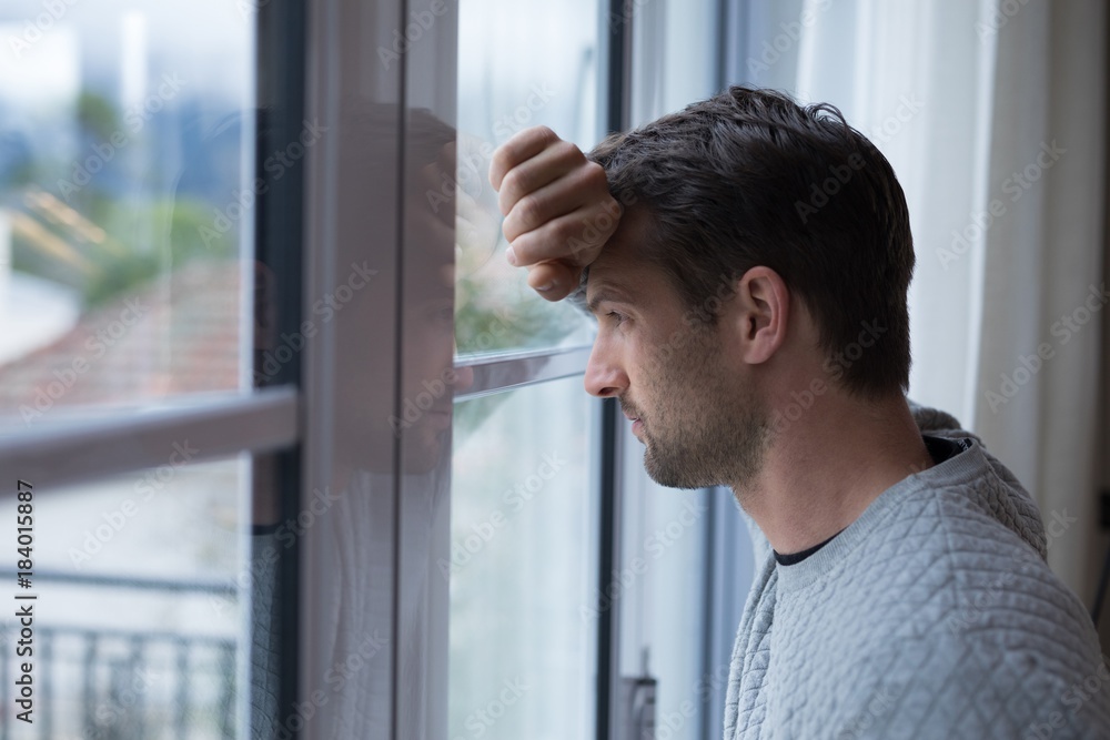 Thoughtful man looking through window