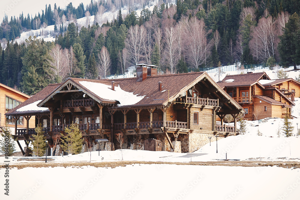 Winter vacation holiday wooden house in the mountains covered with snow and blue sky