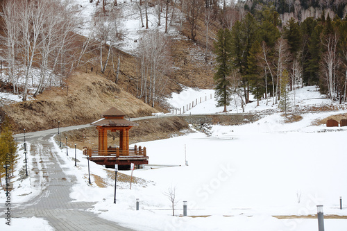 Wooden gazebo on a mountain road in the winter mountains