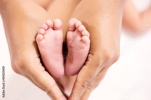 Parent holding in the feet of newborn baby. © PRASERT