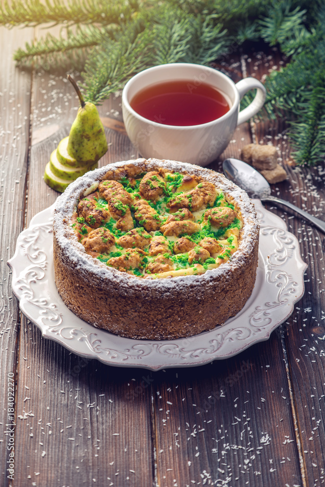 Homemade Christmas or New Year holiday pear pie decorated in a rustic style. Concept of festive desserts