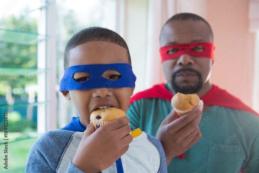 Father and son having muffin at home