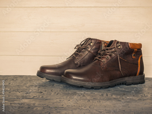 Pair of brown men's classic shoes on the dark floor wooden walls. Brutal men's shoes.