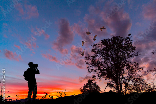 Fototapeta Naklejka Na Ścianę i Meble -  Silhouette photographer documenting a sunset. 