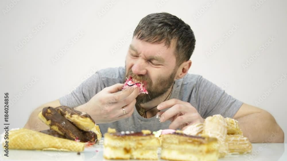 bearded man devours a cake. harmful but delicious food bearded man devours a cake. harmful but delicious food