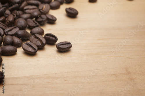 Coffee beans on the wooden board.Close up shot with selective focus.