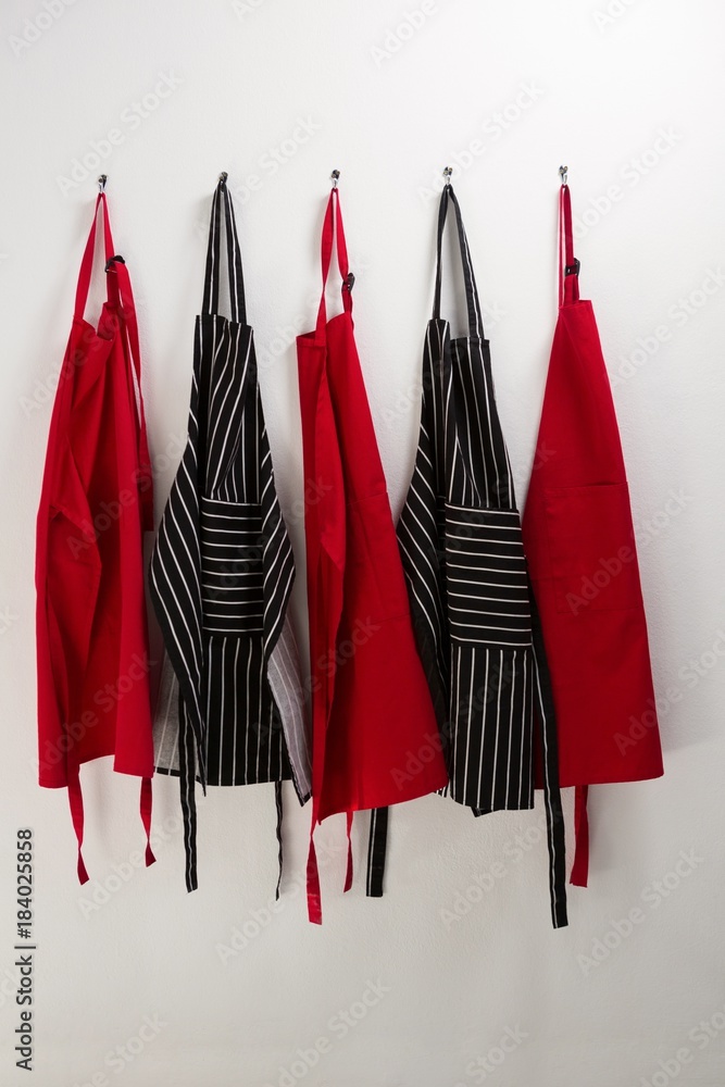 Various aprons hanging on hook Various aprons hanging on hook