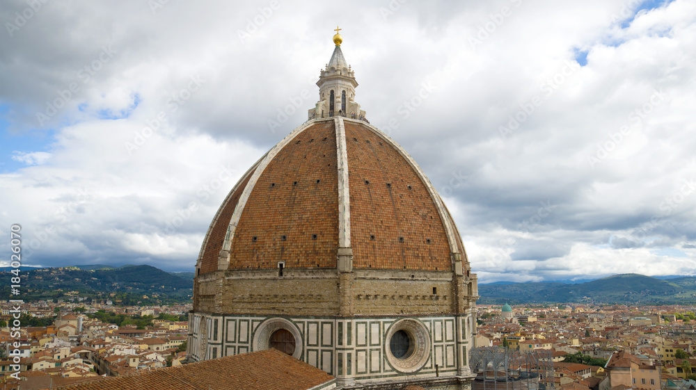Dome of Cathedral of Santa Maria del Fiore close up against the background of the cloudy sky. Florence, Italy