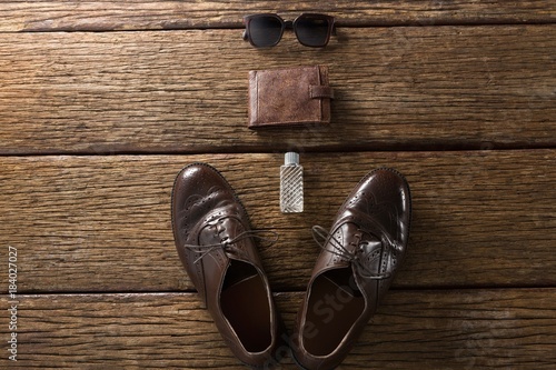 Shoes, perfume, wallet and sunglasses on wooden plank