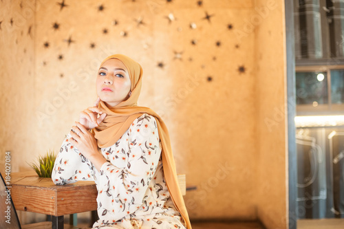 Muslim Hijab Fashion Portraiture.Beautiful young Muslim girl with daily casual outfit and hijab at Cafe.