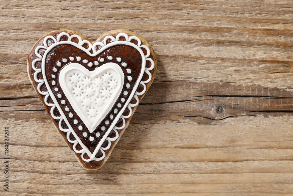 Gingerbread cookie in heart shape on wood Gingerbread cookie in heart shape on wood