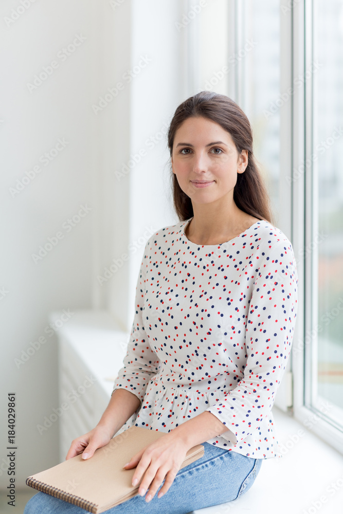 Modern student in casualwear looking at camera during break between lessons Modern student in casualwear looking at camera during break between lessons