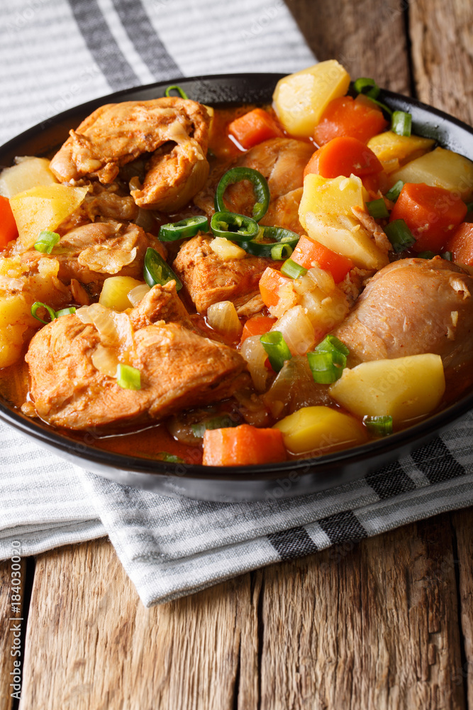 Spicy chicken stew with vegetables close-up on the table. vertical Spicy chicken stew with vegetables close-up on the table. vertical