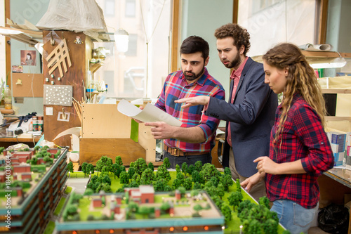 Three landscape designers having discussion of city layout model