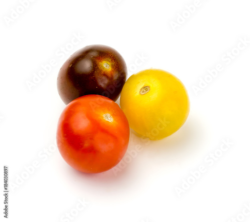 Three colorful fresh cherry tomatoes on white