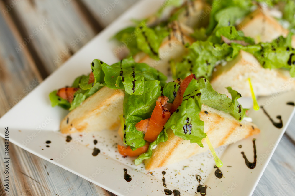 Sandwichies on a white plate on a wooden table Sandwichies on a white plate on a wooden table