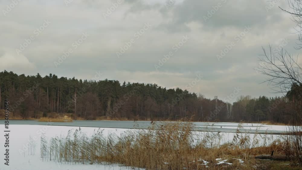 Winter low clouds move over the frozen forest lake. TimeLapse. Winter low clouds move over the frozen forest lake. TimeLapse.