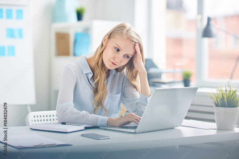 Young female concentrating on network while preparing for report or looking for online data for seminar Young female concentrating on network while preparing for report or looking for online data for seminar