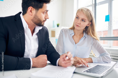Wallpaper Mural Serious businesswoman listening to her colleague during discussion of new online business trends Torontodigital.ca