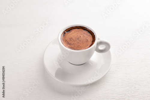 Espresso coffee cup on a white wooden background. Top view. Free space for text.