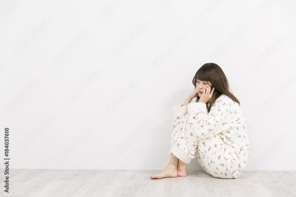パジャマで携帯電話を使う女性