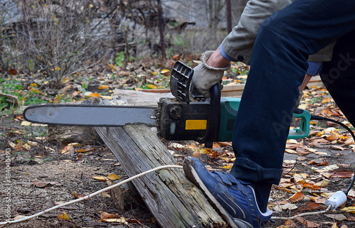 Men were sawing wood using an electric green saw.