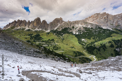 group of hikers descending a hiking trail in the Dolomites in Italy after completing a Via Ferrata on a beautiful autumn day after a fresh snow fall