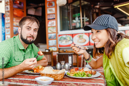 Man and woman tourists eat in the Turkish restaurant local cuisine and try kebabs