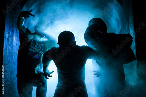 Silhouette of three men in the blue light photo