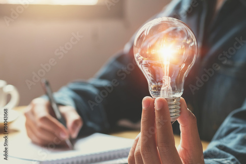 new idea and creative concept for business woman hand holding light bulb photo