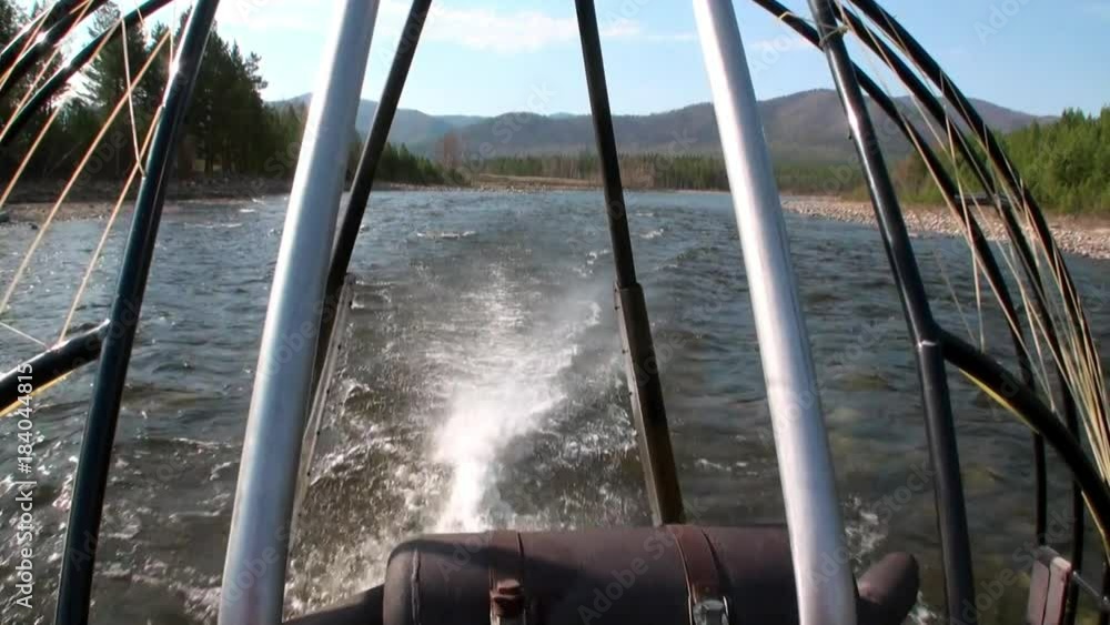 Airboat airglider on mountain river Temnik. Clean water and stone rock bottom in spring. Border of Baikal State Nature Biosphere Reserve. Ecotourism in Siberia of Russia. Airboat airglider on mountain river Temnik. Clean water and stone rock bottom in spring. Border of Baikal State Nature Biosphere Reserve. Ecotourism in Siberia of Russia.