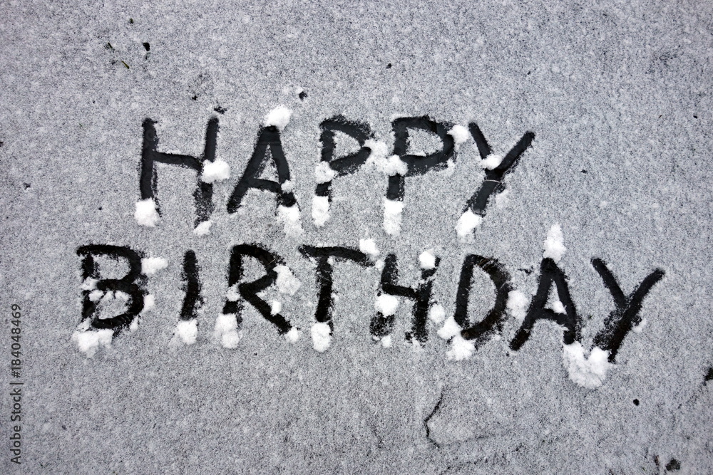 Happy birthday card with handwritten lettering in snow Happy birthday card with handwritten lettering in snow