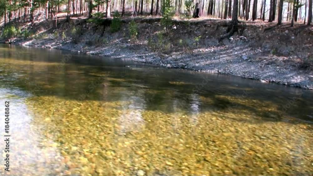 Riverside of mountain river Temnik at border of Baikal. Clean water and stone rock bottom in spring. Ecotourism in Siberia of Russia. Riverside of mountain river Temnik at border of Baikal. Clean water and stone rock bottom in spring. Ecotourism in Siberia of Russia.
