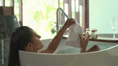 Woman taing towel and dries her face during bath, steadycam shot, slow motion shot 
 photo