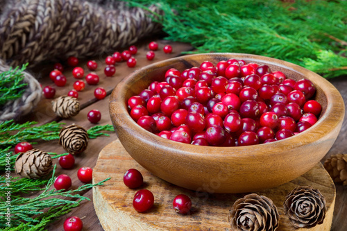 Schilderij op canvas Berries cranberries, drink, jam spruce branches, cones on a dark background with