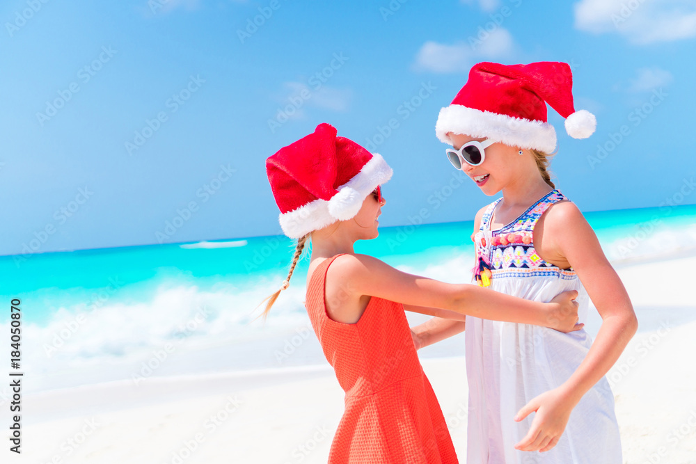Obraz premium Adorable little girls on Christmas beach vacation.