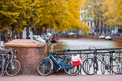 Bike on the bridge in Amsterdam, Netherlands. Beautiful view of canals in autumn